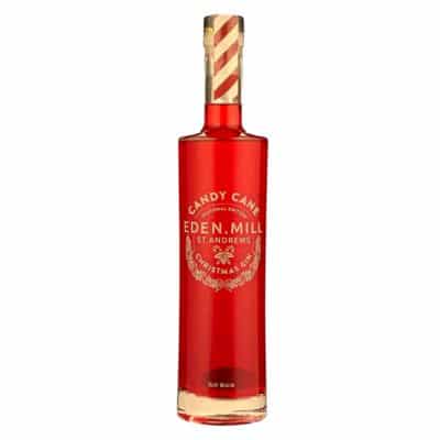 A festive image of a bottle of Eden Mill Candy Cane Christmas Gin with a candy cane garnish, perhaps with a glass of the gin and tonic in the background.