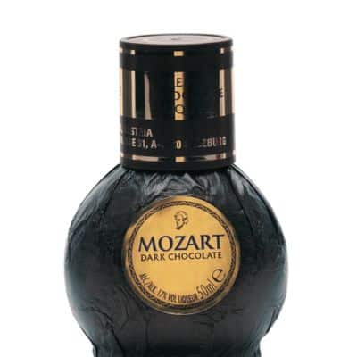 A close-up of a Mozart Dark Chocolate Liqueur miniature.