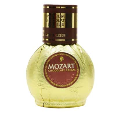 A round gold bottle of Mozart Chocolate Cream liqueur with a red cap.