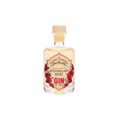 A miniature bottle of Secret Garden Apothecary Rose Gin with a wooden cap.