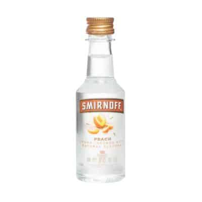 A miniature bottle of Smirnoff Peach Vodka with a golden cap.