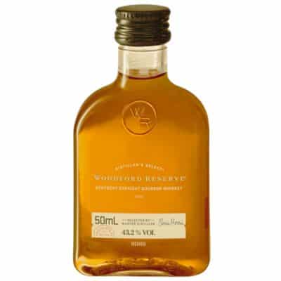 A miniature bottle of Woodford Reserve Bourbon, a Kentucky Straight Bourbon Whiskey with a rich amber color.